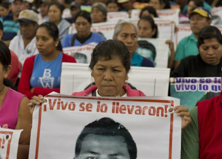 Ayotzinapan kadonneiden opiskelijoiden omaiset ja ystävät vaativat tietoa läheistensä kohtalosta syyskuussa Mexico Cityssä.