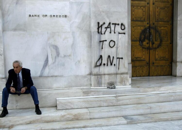 Kreikan keskuspankin seinään on kirjoitettu graffiti ?IMF ulos?.