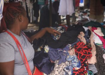 Myyjä esittelee tuotteitaan asiakkaalle käytettyjen vaatteiden torilla Zimbabwen Mutaressa.