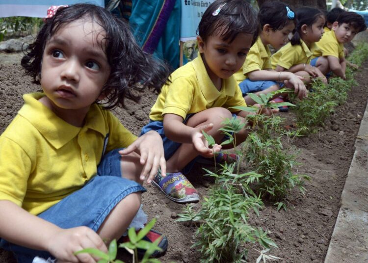Intialaisia pikkukoululaisia istuttamassa puita Kolkatassa.