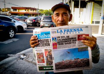 Julio Antonio Ramírez myy sanomalehtiä Bernal-kadun kulmassa San Salvadorissa. Painettujen sanomalehtien vähentyminen on pienentänyt hänen tulojaan ja kuvastaa digitaalisen murroksen vaikutuksia Keski-Amerikan mediakentässä.