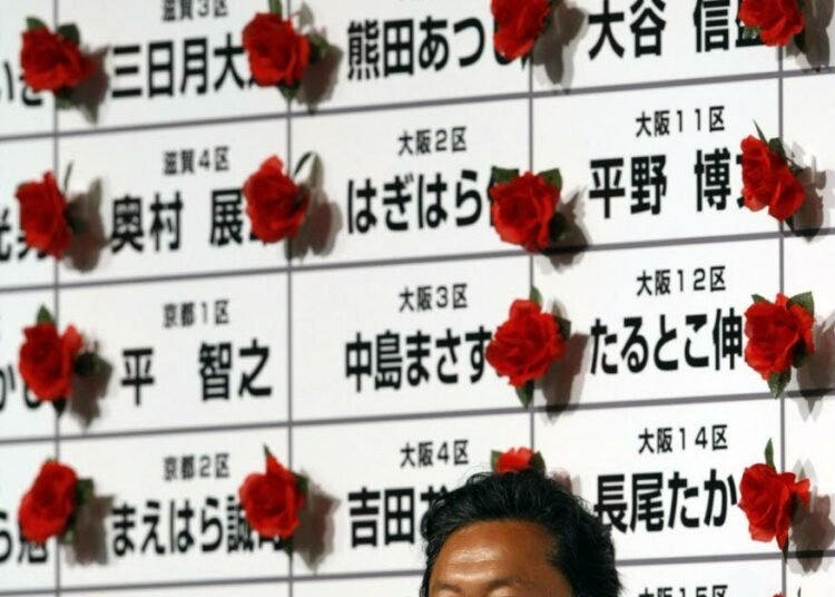 Demokraattisen puolueen johtaja Yukio Hatoyama riemuitsi puolueensa päämajassa maanantaina. Taustalla on japanilaiseen tyyliin taulu, johon on merkitty ruusukkeilla puolueen valituksi tulleet ehdokkaat.