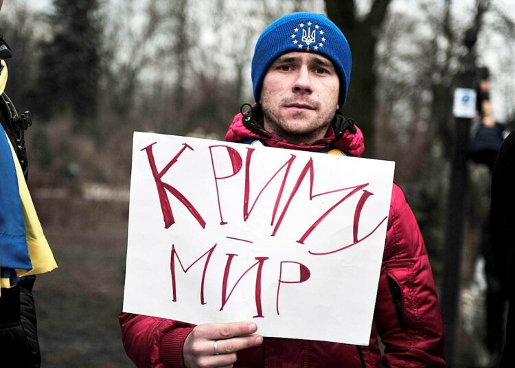 Rauha Krimille, luki mielenosoittajan kyltissä torstaina.