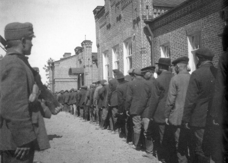 Kova oli tehtaalaisten kohtalo. Punakaartilaisia Kouvolan vankileirillä toukokuussa 1918. Kirjan kuvitusta.