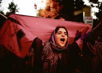 Purppuranpunaista kangasta kantanut iranilainen nainen juhli maltillisen presidenttiehdokkaan Hassan Rouhanin voittoa maan presidentinvaaleissa viime lauantaina Iranin pääkaupungissa Teheranissa. Purppura oli Rouhanin vaalikampanjan virallinen väri.