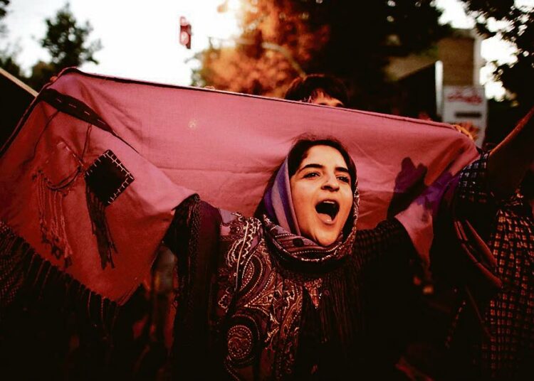 Purppuranpunaista kangasta kantanut iranilainen nainen juhli maltillisen presidenttiehdokkaan Hassan Rouhanin voittoa maan presidentinvaaleissa viime lauantaina Iranin pääkaupungissa Teheranissa. Purppura oli Rouhanin vaalikampanjan virallinen väri.