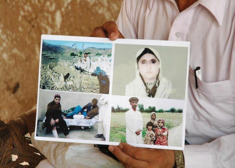 Yhdysvaltojen Pakistaniin tekemissä  lennokki-iskuissa kuolleen naisen poika näyttää kuvaa äidistään sekä iskussa haavoittuneiden lastensa kuvia.