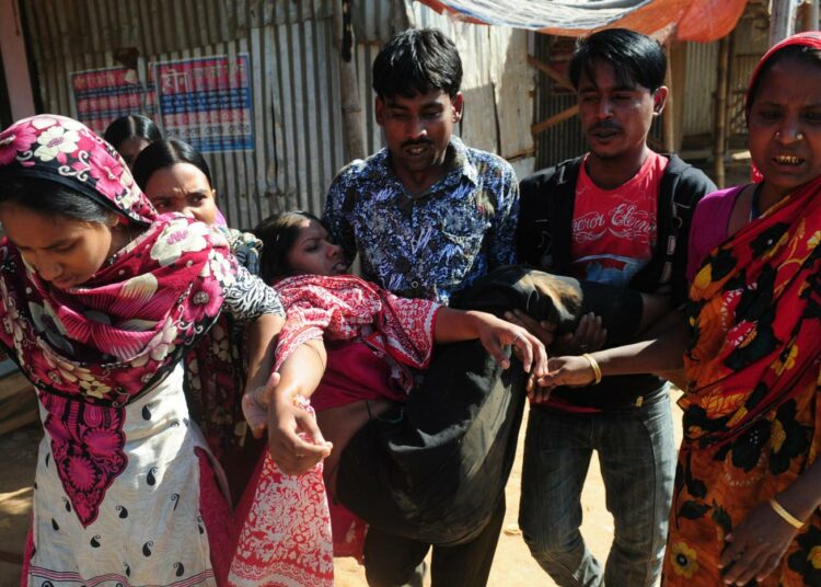 Bangladeshilaiset tekstiilityöläiset kantavat loukkaantunutta työtoveriaan Ashulian teollisuusalueella lähellä Dhakaa kaksi viikkoa sitten. Poliisi hajotti väkivalloin minimipalkkalain toteuttamista vaatineiden työntekijöiden mielenosoituksen.