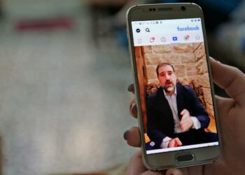 Nainen katsoi viime viikolla Damaskoksessa liikemies Rami Makhloufin valitusvideota Facebookista.