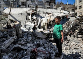 Lapsi seisoo romahtaneen rakennuksen raunioilla Rafahissa Gazassa 9. huhtikuuta.
