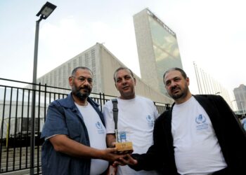 Palestiinalaisdelegaation jäsenet Basem al Baz, Majed Abdulfattah ja Ahmad Dari esittelivät symbolista tuolia YK:n päämajan edessä New Yorkissa keskiviikkona.