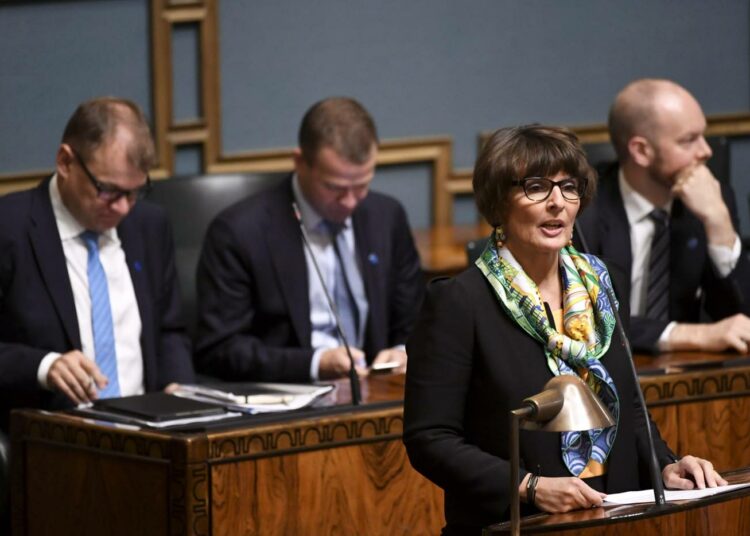 Liikenne- ja viestintäministeri Anne Berner vastasi välikysymykseen. Takana kolmen hallitusryhmän ykkösmiehet.