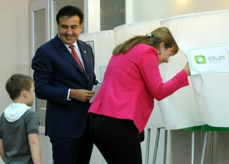 Presidentti Mihail Saakashvili äänestämässä perheineen Tbilisissä maanantaina.