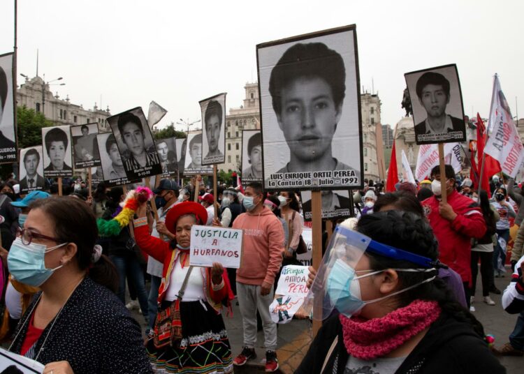 Mielenosoittajat muistuttavat Alberto Fujimorin ihmisoikeusrikoksista. Kyltissä lukee: "oikeutta orvoiksi jääneille".