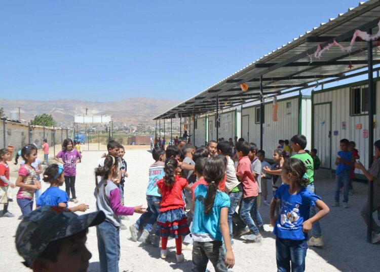 Lapset viihtyvät koulun pihalla, joka on epävirallisessa pakolaisleirissä usein ainoa turvallinen paikka leikkiä ja pelata.