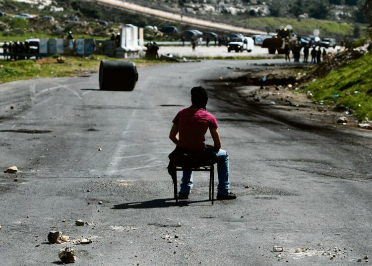 Palestiinalaismielenosoittaja odotti lähestyviä Israelin sotilaita Ofran vankilaan vievällä tiellä.