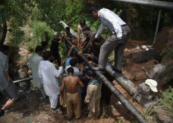 Pakistanilaiset hakevat vettä vuotavasta vesiputkesta Islamabadissa Pakistanissa kesäkuussa. Energiapula ja korkeat lämpötilat tekevät elämän vaikeaksi erityisesti kesällä.