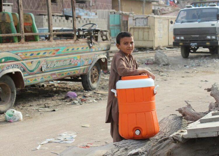 Avustusjärjestö Oxfam kertoo, että köyhyyden vähentäminen hoituisi vain sillä, että rikkaat maksaisivat pikkiriikkisen enemmän veroja. Kuvan poika Pakistanin Karachista on hakemassa köyhälle perheelleen vettä vesihanasta, jonka rikas perhe on hyväntekeväisyytenä asennuttanut kotitalonsa eteen.