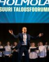 Hölmölä – suuri talousfoorumi esitettiin entisen Kauppakorkeakoulun juhlasalissa. Kuvassa Juho Uusitalo ja kuoro.
