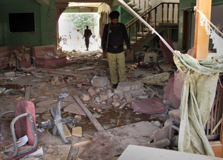 Poliisit tutkivat World Vision -järjestön tiloihin tehdyn iskun jälkiä Oghin kylässä Pakistanin Luoteisessa rajamaakunnassa.