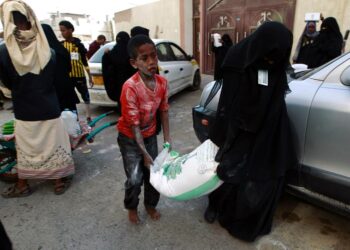 Ihmisiä hakemassa avustusjärjestöjen jakamia ruokatarvikkeita Jemenin pääkaupungissa Sanaassa.