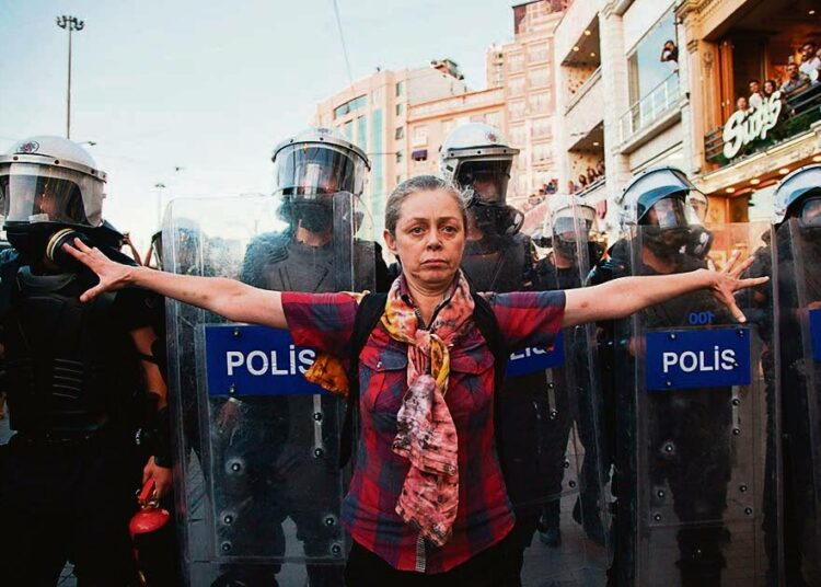 Mielenosoittaja kohtasi poliisit Taksimin aukiolla Istanbulissa 20. heinäkuuta.