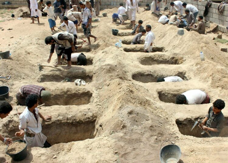 Lapsille kaivetaan hautoja Jemenin Dahyanissa saudikoalition ilmahyökkäyksen jälkeen.