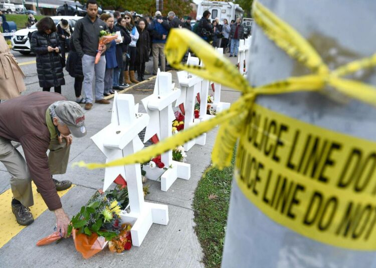 Ihmisiä jättämässä kukkia Pittsburghissa viime perjantaina joukkomurhan tapahtumapaikkana olleen synagogan edustalle.