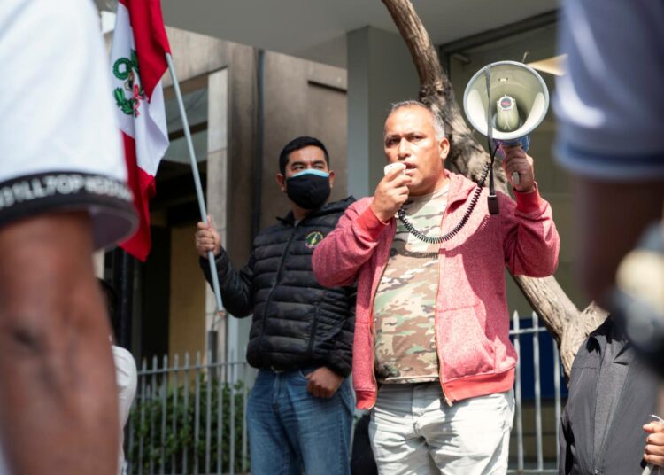 Walter Villalobos Barturen puhuu megafoniin kommunisminvastaisessa mielenosoituksessa.