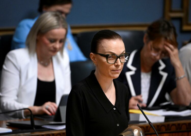 Minja Koskela piti vasemmistoliiton ryhmäpuheenvuoron. Taustalla vasemmalla valtiovarainministeri Riikka Purra (ps.).