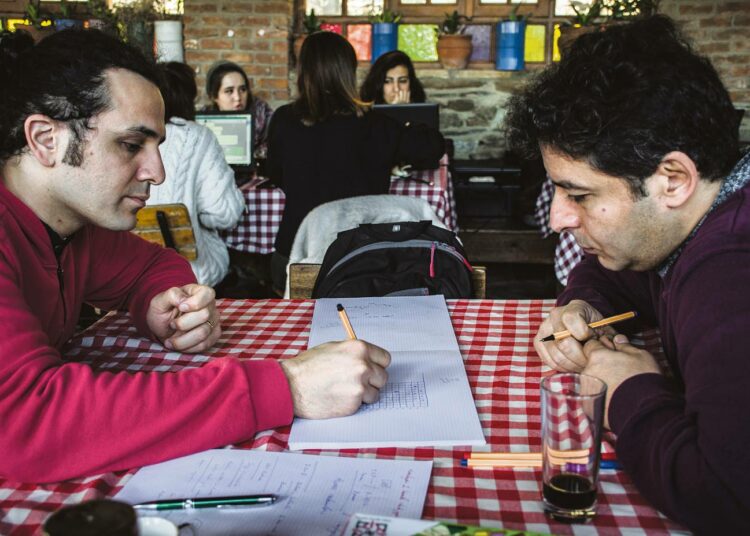 Hakan Güntürkün ja Özer Öztürk kokeilevat kehittämäänsä oppimispelia aamiaispöydässä.