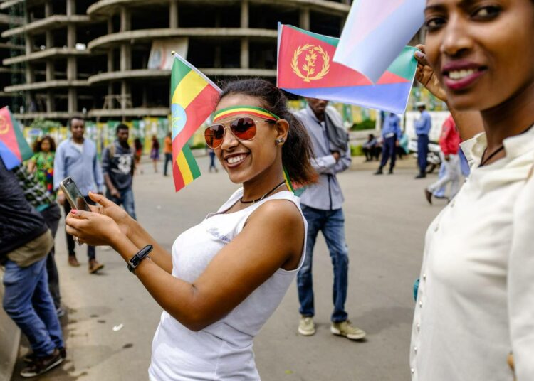 Etiopian ja Eritrean lipuilla koristautunut nainen otti itsestään selfien maiden johtajien sovintotapaamisen alla Etiopian pääkaupungissa Addis Abebassa.
