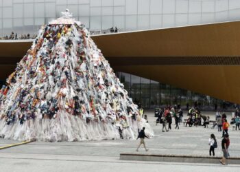 Taiteilija Kaisa Salmi saarnaa kymmenen tuntia kymmenen metrin korkeudessa muovipukuun pukeutuneena osana Plastic Mama -teosta Suomen EU-puheenjohtajakauden avajaistapahtumassa Kansalaistorilla Helsingissä.