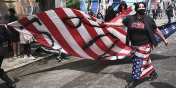 Seattlelainen mielenosoittaja kantoi Yhdysvaltojen tähtilippua, johon oli spraymaalattu sanat rakkaus ja raivo.