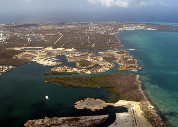 Verokäärme on tunkeutumassa paratiisiin. Kuvassa Caymansaarten pääsaari Grand Cayman.