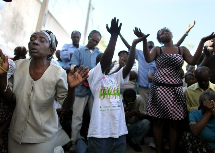 Haitilaisia rukoilemassa sunnuntaina ulkoilmamessussa Port-au-Princessä.