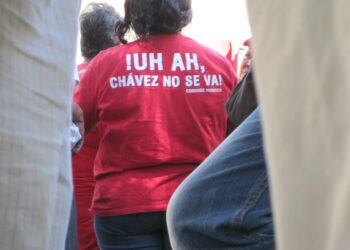 Chávezin kannattajia kuuntelemassa presidentin joka sunnuntaisen tv-ohjelman filmausta. Paidan selkämyksessä näkyy yksi heidän tavallisista iskulauseistaan "Uh ah, Chávez ei lähde".