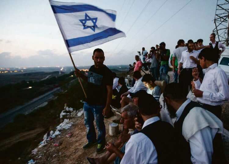Israelilaisia katselemassa Gazan moukarointia kukkulalla Sderotin kaupungissa, joka sijaitsee aivan Gazan rajalla.