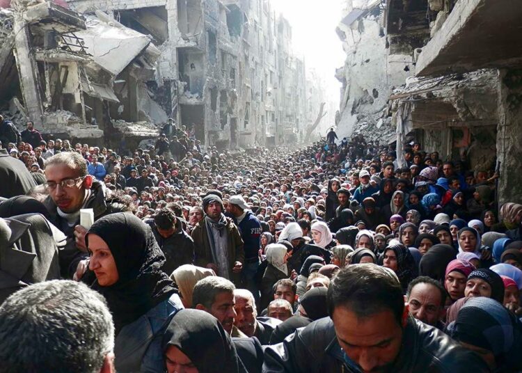 Tuhannet palestiinalaiset pakolaiset jonottivat ruoka-apua Syyrian pääkaupungin Damaskoksen lähiössä tammikuussa. YK:n palestiinalaispakolaisten avustusjärjestön levittämä kuva julkaistiin Helsingin Sanomissa maaliskuussa.