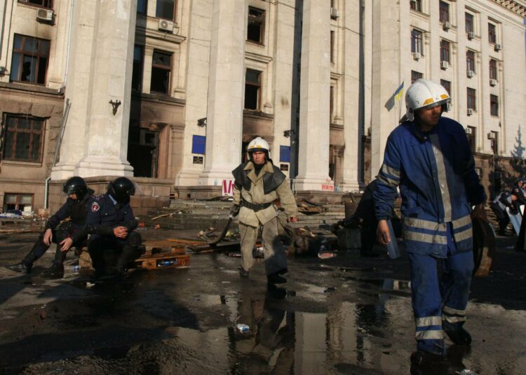 Palomiehet kokoilivat lauantaina välineitään palaneen ammattiliittojen talon edustalla Odessassa.