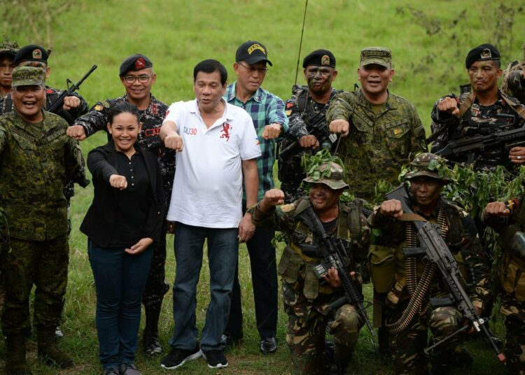 Filippiinien presidentti Rodrigo Duterte (valkoisessa paidassa) pitää laista ja järjestyksestä. Poliisin lisäksi hän on armeijan ystävä.