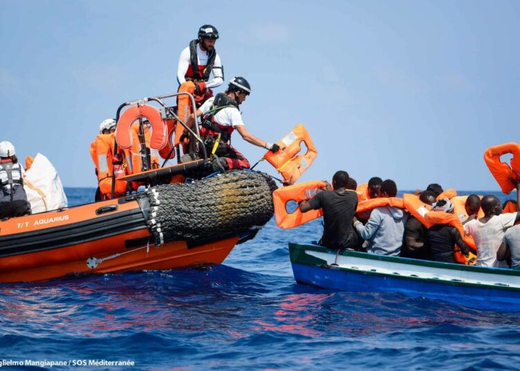 SOS Méditerranéen ja Lääkärit ilman rajoja -järjestön pelastusalus Aquariuksesta ojennetaan pelastusliivejä Välimeren ylittämistä puuveneellä yrittäville ihmisille. Aquarius poimi viime viikolla merestä Libyan rannikolta 141 Eurooppaan pyrkivää ihmistä.