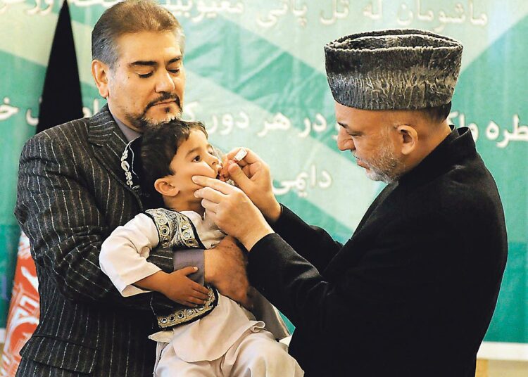 Presidentti Hamid Karzai (oik.) näyttää kansalaisille mallia poliorokottamisen tekniikasta. Vieressä terveysministeri Sayed Muhammad Amin Fatimi.