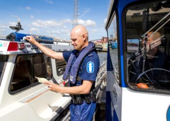 Jyrki Lehto tarkastaa veneen paperit.