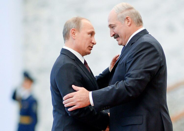 Vladimir Putin ja Aleksandr Lukašenko tervehtivät toisiaan Minskissä perjantaina.