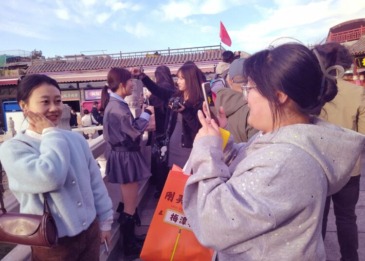 Kiinalaisnuoret ottivat kännykkäkuvia toisistaan Houhai-järven alueella Pekingissä lokakuussa.