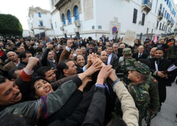 Mielenosoittajat puristivat sotilaan kättä torstaina Tunisissa. He vaativat kaikkien entistä hallitusta palvelleiden tuomareiden erottamista.