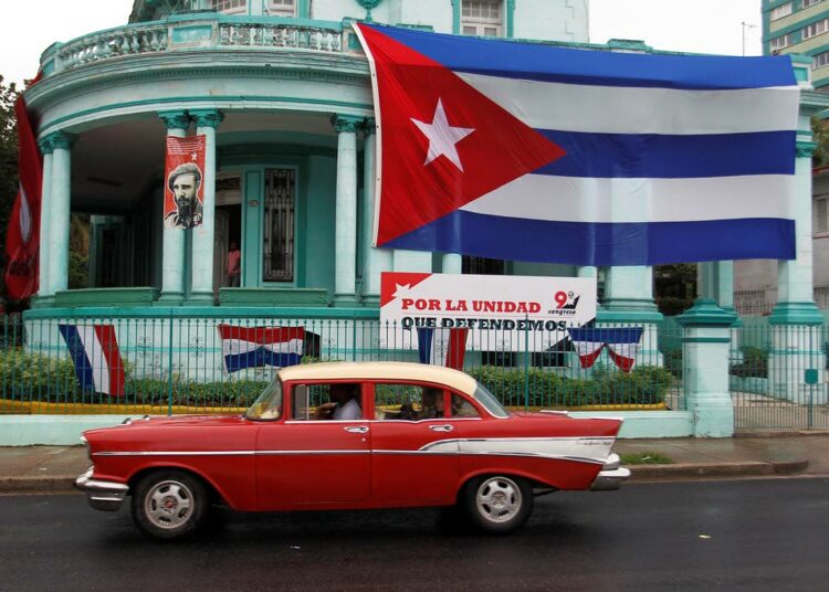 Yhdysvalloissa valmistettu Chevrolet vuosimallia 1957 ohittaa Havannassa Kuuban vallankumouksen puolustuskomitean päämajaa, jota koristaa Fidel Castron kuva ja maan lippu.