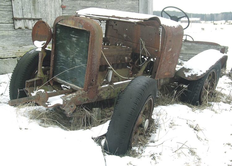 Ikivanha traktorin romu Iniön kunnantaloa ja kirkkoa vastapäätä kuvastelee saaristokuntien asukkaiden mielialoja kuntaliitoksesta.