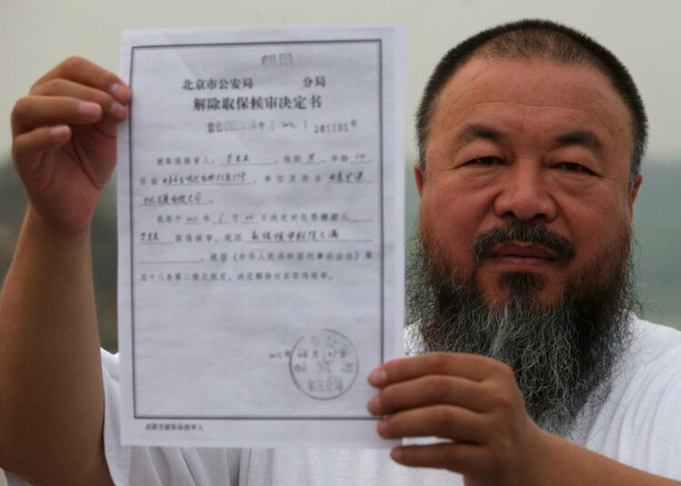 Taiteilija Ai Weiwei näytti Pekingissä viime vuoden kesäkuussa paperia, jossa vahvistettiin hänen vankilatuomionsa päättyminen.